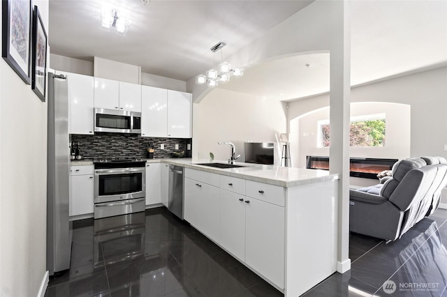14335 Simonds Rd NE Unit A305, Kirkland, WA 98034 - kitchen with appliances with stainless steel finishes, open floor plan, a peninsula, decorative backsplash, and white cabinetry