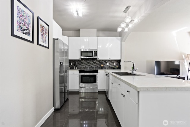 14335 Simonds Rd NE Unit A305, Kirkland, WA 98034 - kitchen with appliances with stainless steel finishes, a peninsula, backsplash, white cabinetry, and light countertops