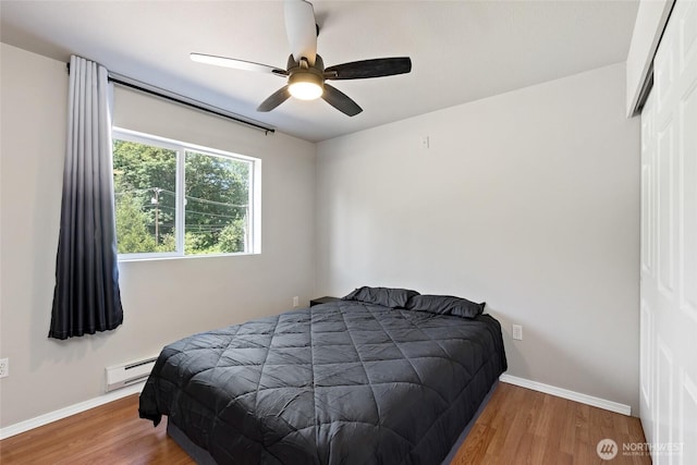 14335 Simonds Rd NE Unit A305, Kirkland, WA 98034 - bedroom featuring baseboard heating, wood finished floors, and a ceiling fan