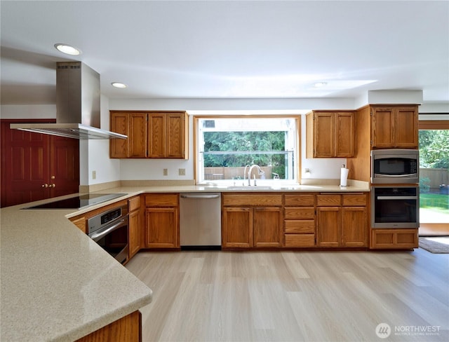 22019 NE 26th Pl, Sammamish, WA 98074 - kitchen featuring stainless steel appliances, wall chimney range hood, brown cabinets, light wood-type flooring, and light countertops
