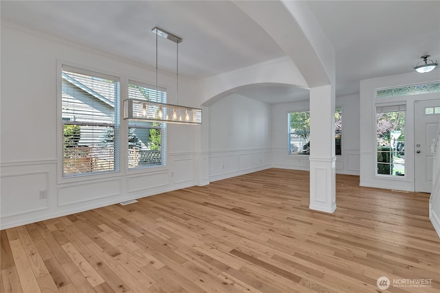 7003 Radius Loop SE, Lacey, WA 98513 - foyer entrance featuring a decorative wall, light wood-style floors, ornamental molding, arched walkways, and wainscoting