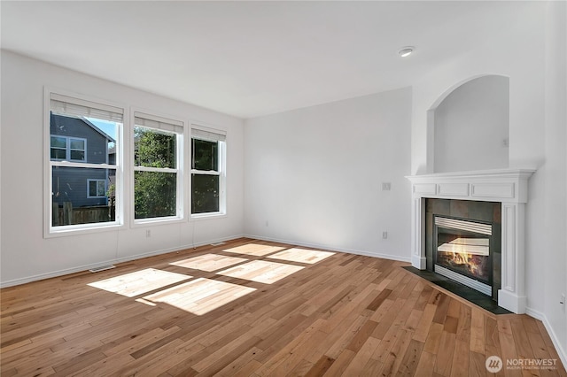 7003 Radius Loop SE, Lacey, WA 98513 - unfurnished living room featuring light wood-style flooring and a tiled fireplace