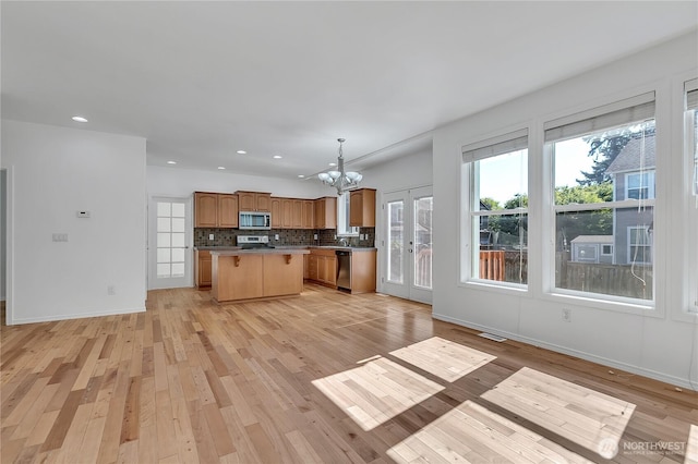 7003 Radius Loop SE, Lacey, WA 98513 - kitchen featuring stainless steel appliances, open floor plan, light wood-style flooring, a kitchen island, and a chandelier