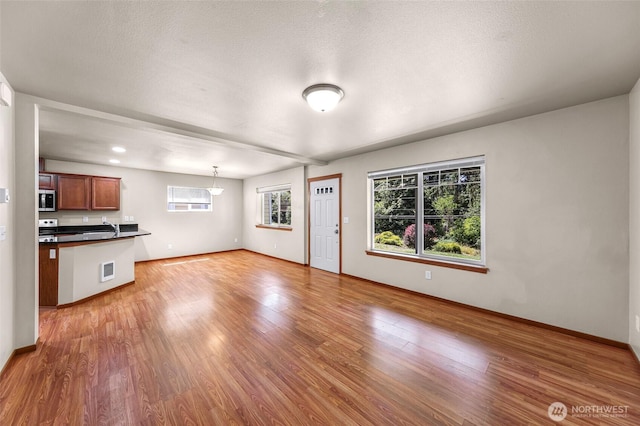1422 Lincoln St, Bellingham, WA 98229 - unfurnished living room with healthy amount of natural light, light wood-style floors, and a textured ceiling