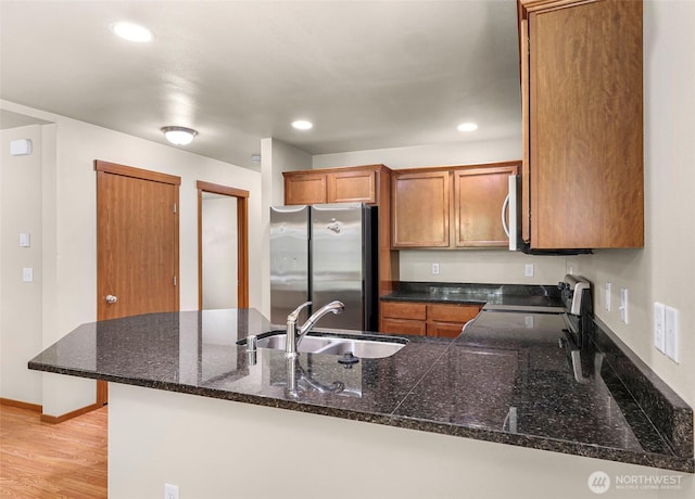 1422 Lincoln St, Bellingham, WA 98229 - kitchen with stainless steel appliances, brown cabinetry, a peninsula, recessed lighting, and light wood-type flooring