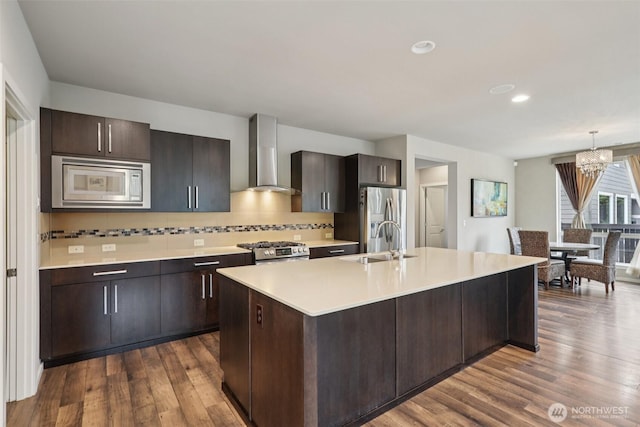 5624 S 344th Ct, Auburn, WA 98001 - kitchen featuring wall chimney exhaust hood, appliances with stainless steel finishes, light countertops, dark wood finished floors, and a center island with sink