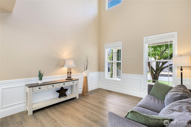 13034 SE 209th Ct, Kent, WA 98031 - sitting room with healthy amount of natural light, a wainscoted wall, light wood finished floors, a decorative wall, and a towering ceiling