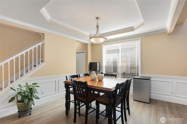 13034 SE 209th Ct, Kent, WA 98031 - dining room featuring a tray ceiling, a decorative wall, ornamental molding, a wainscoted wall, and stairs