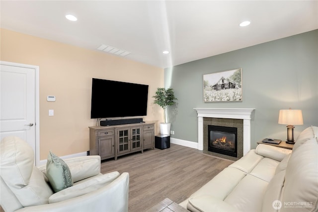 13034 SE 209th Ct, Kent, WA 98031 - living room featuring light wood-type flooring, a tiled fireplace, and recessed lighting