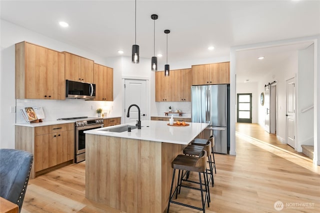 251 Sweet Gum Dr, Blaine, WA 98230 - kitchen featuring appliances with stainless steel finishes, light wood-type flooring, an island with sink, backsplash, and recessed lighting