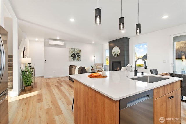 251 Sweet Gum Dr, Blaine, WA 98230 - kitchen featuring stainless steel dishwasher, a wall unit AC, a fireplace, light wood finished floors, and open floor plan