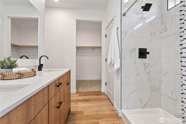 251 Sweet Gum Dr, Blaine, WA 98230 - bathroom with wood finished floors, double vanity, a marble finish shower, a walk in closet, and recessed lighting