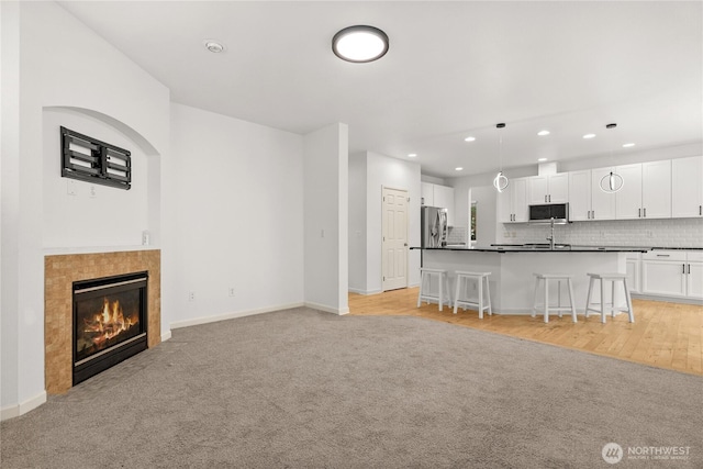 7701 Rushmore Ave NE, Lacey, WA 98516 - living room featuring recessed lighting, light carpet, a fireplace, and light wood finished floors