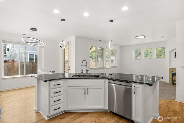 7701 Rushmore Ave NE, Lacey, WA 98516 - kitchen featuring stainless steel dishwasher, light wood-style flooring, dark stone countertops, white cabinets, and recessed lighting