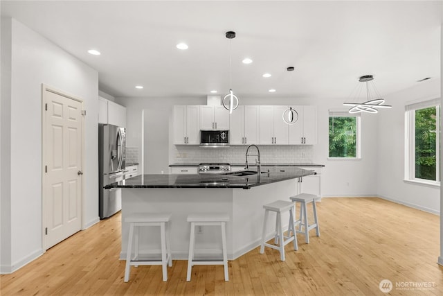 7701 Rushmore Ave NE, Lacey, WA 98516 - kitchen with stainless steel appliances, decorative backsplash, white cabinetry, light wood-type flooring, and recessed lighting