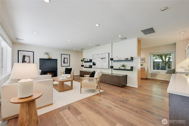 804 109th Ave SE, Bellevue, WA 98004 - living room with light wood-style floors, a lit fireplace, and recessed lighting