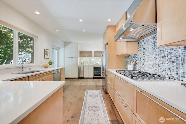 804 109th Ave SE, Bellevue, WA 98004 - kitchen featuring exhaust hood, appliances with stainless steel finishes, light brown cabinets, decorative backsplash, and light wood-type flooring