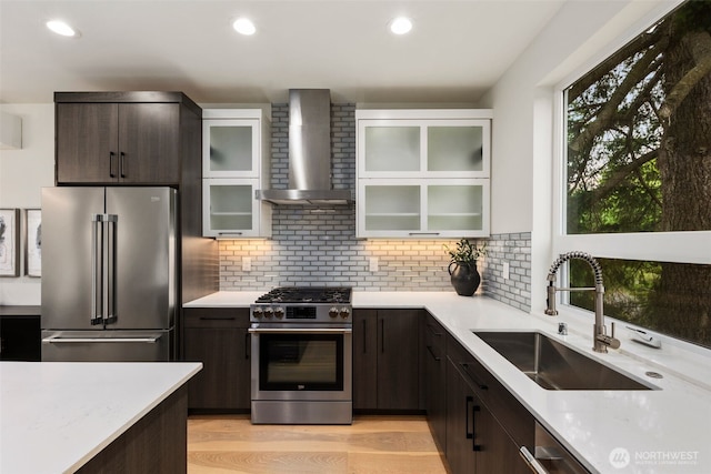 5404 26th Ave SW, Seattle, WA 98106 - kitchen with stainless steel appliances, wall chimney range hood, dark brown cabinets, decorative backsplash, and recessed lighting