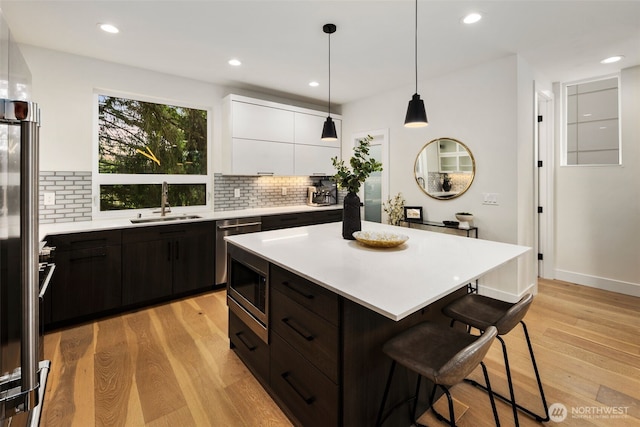 5404 26th Ave SW, Seattle, WA 98106 - kitchen with a kitchen bar, white cabinetry, light countertops, tasteful backsplash, and modern cabinets
