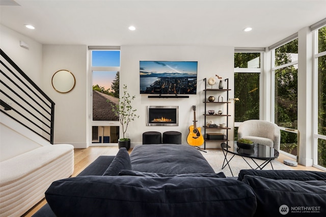 5404 26th Ave SW, Seattle, WA 98106 - living area with expansive windows, healthy amount of natural light, light wood-style floors, recessed lighting, and a warm lit fireplace