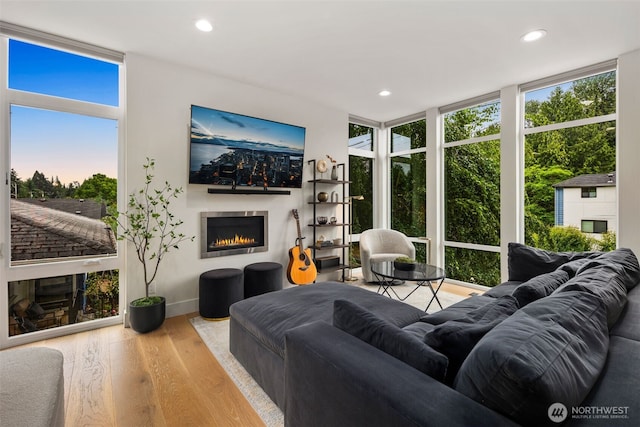 5404 26th Ave SW, Seattle, WA 98106 - living area with a lit fireplace, wood finished floors, plenty of natural light, a wall of windows, and recessed lighting