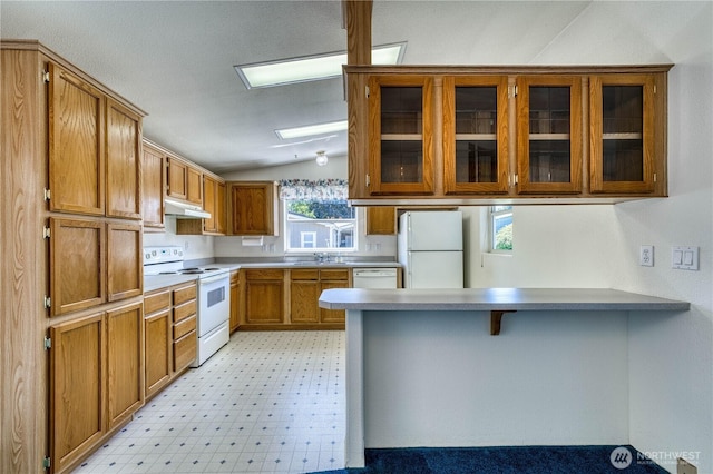 1915 140th St E Unit 193, Tacoma, WA 98445 - kitchen featuring white appliances, brown cabinetry, a peninsula, vaulted ceiling, and glass insert cabinets