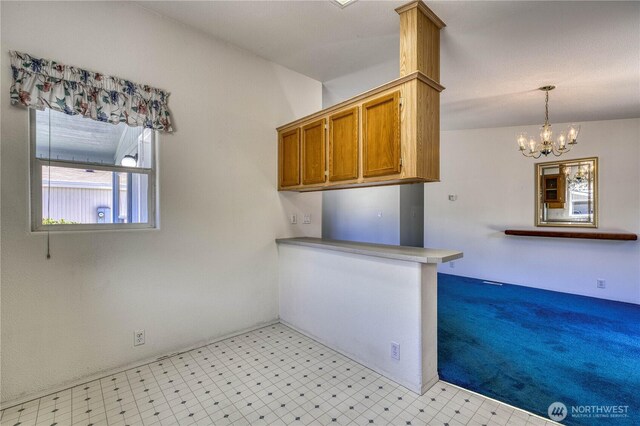 1915 140th St E Unit 193, Tacoma, WA 98445 - kitchen with brown cabinetry, light floors, a chandelier, hanging light fixtures, and a peninsula