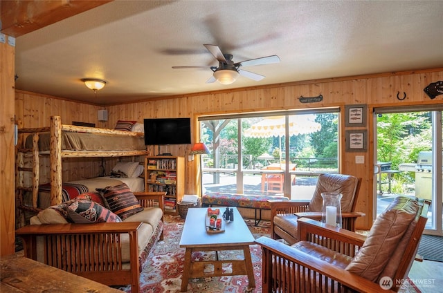 13285 Wye Lake Blvd SW, Port Orchard, WA 98367 - living area with wooden walls, ceiling fan, ornamental molding, and a textured ceiling