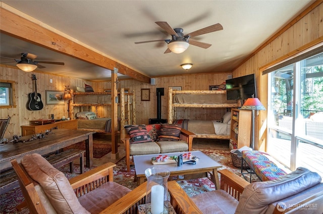 13285 Wye Lake Blvd SW, Port Orchard, WA 98367 - living room featuring ceiling fan, wood walls, healthy amount of natural light, a wood stove, and beamed ceiling
