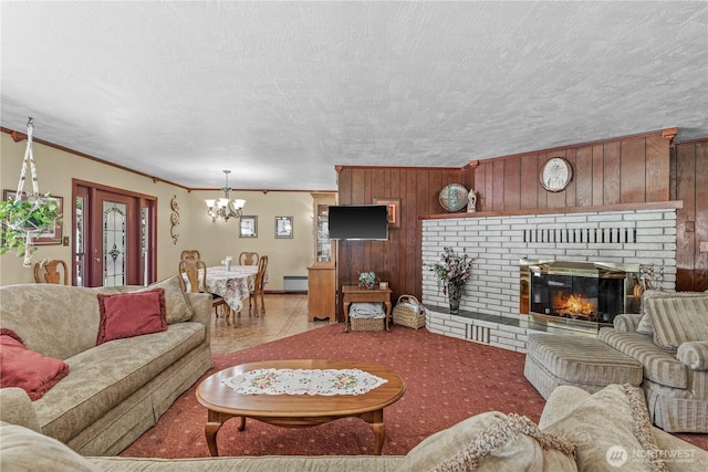 9327 E Leavenworth Rd, Leavenworth, WA 98826 - living area with a chandelier, wooden walls, a fireplace, and ornamental molding