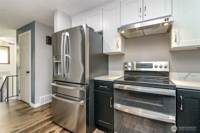 416 142nd Street Ct S, Tacoma, WA 98444 - kitchen with stainless steel appliances, under cabinet range hood, white cabinets, and wood finished floors
