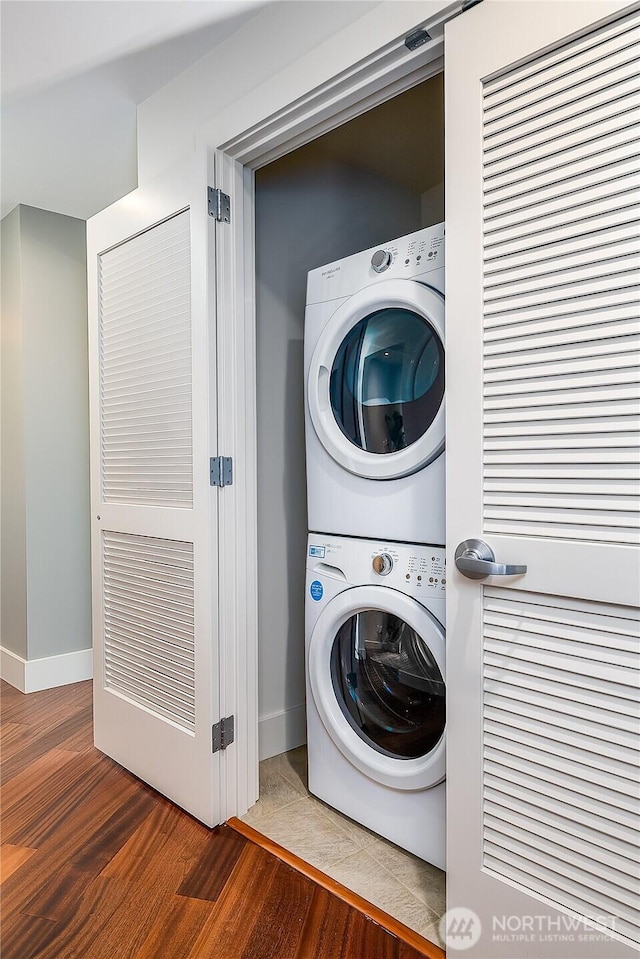 2121 Terry Ave Unit 1402, Seattle, WA 98121 - laundry area with stacked washing machine and dryer and wood finished floors