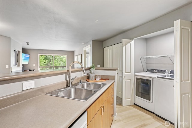 7711 NE 175th St Unit E110, Kenmore, WA 98028 - kitchen featuring washing machine and dryer, light wood finished floors, and light countertops