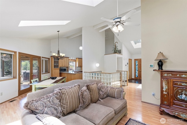 2815 60th Street Ct NW, Gig Harbor, WA 98335 - living area with a skylight, high vaulted ceiling, a chandelier, light wood finished floors, and healthy amount of natural light