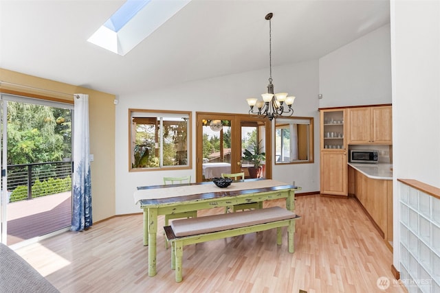 2815 60th Street Ct NW, Gig Harbor, WA 98335 - dining area with a chandelier, light wood finished floors, high vaulted ceiling, and a skylight