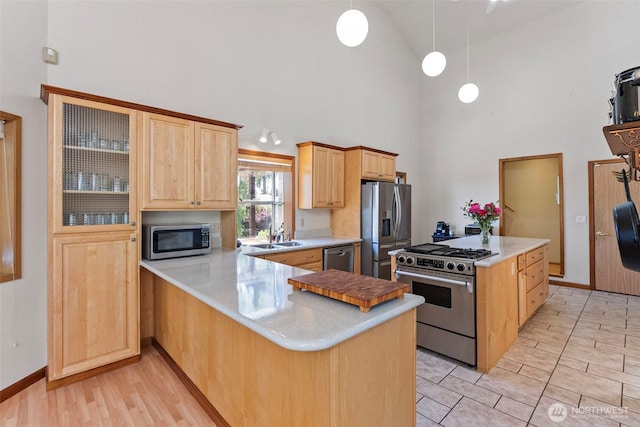 2815 60th Street Ct NW, Gig Harbor, WA 98335 - kitchen featuring appliances with stainless steel finishes, high vaulted ceiling, light brown cabinetry, light countertops, and a peninsula