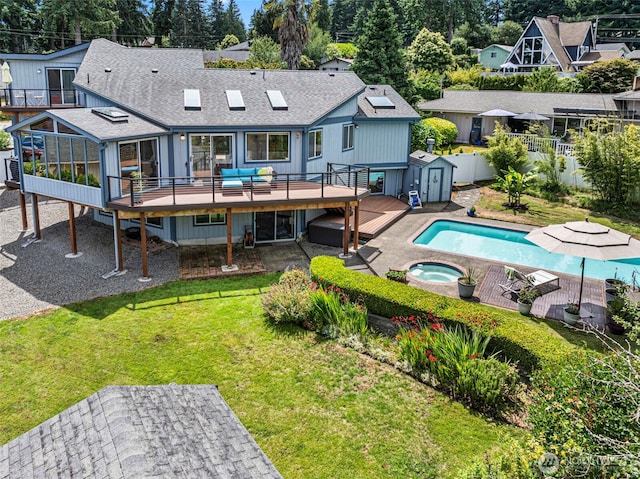 2815 60th Street Ct NW, Gig Harbor, WA 98335 - rear view of house featuring a wooden deck, a storage unit, an in-ground hot tub, roof with shingles, and a fenced backyard