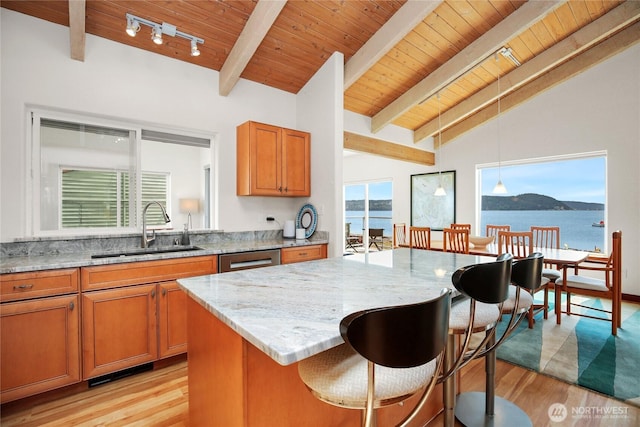 451 Beach Dr, Sequim, WA 98382 - kitchen featuring light stone countertops, light wood finished floors, wooden ceiling, brown cabinets, and a kitchen bar