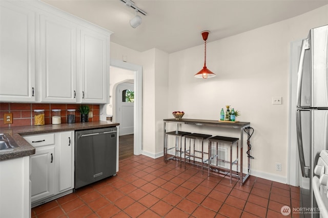 5803 Latona Ave NE, Seattle, WA 98105 - kitchen with stainless steel appliances, dark countertops, white cabinetry, and decorative backsplash