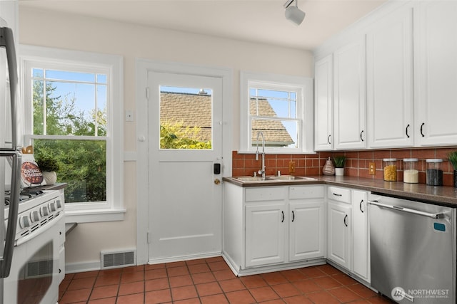 5803 Latona Ave NE, Seattle, WA 98105 - kitchen with stainless steel dishwasher, dark tile patterned flooring, healthy amount of natural light, and dark countertops