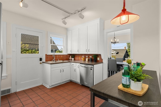 5803 Latona Ave NE, Seattle, WA 98105 - kitchen featuring stainless steel dishwasher, rail lighting, dark countertops, tasteful backsplash, and white cabinets