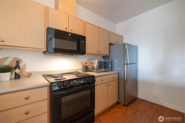 13301 SE 79th Pl Unit B-402, Newcastle, WA 98059 - kitchen featuring black appliances, light brown cabinets, light countertops, and light wood-style flooring