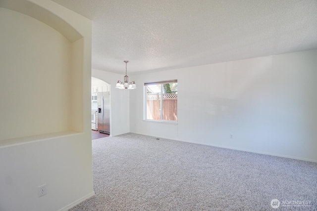 3300 NE 90th Cir, Vancouver, WA 98665 - carpeted spare room featuring a chandelier, arched walkways, and a textured ceiling