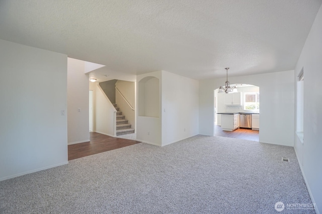 3300 NE 90th Cir, Vancouver, WA 98665 - unfurnished living room featuring light carpet, a chandelier, stairway, and a textured ceiling