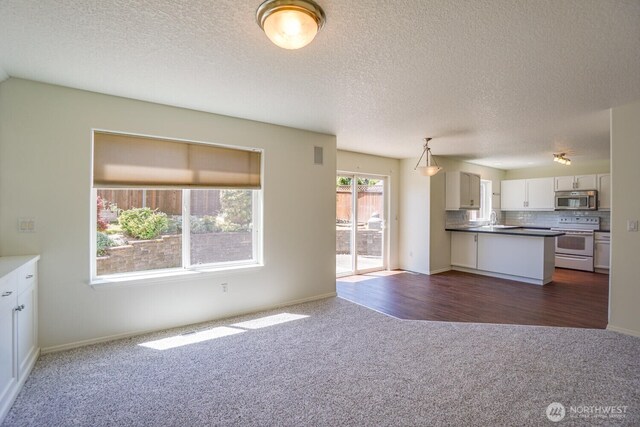 3300 NE 90th Cir, Vancouver, WA 98665 - kitchen with white electric range, stainless steel microwave, dark carpet, open floor plan, and tasteful backsplash