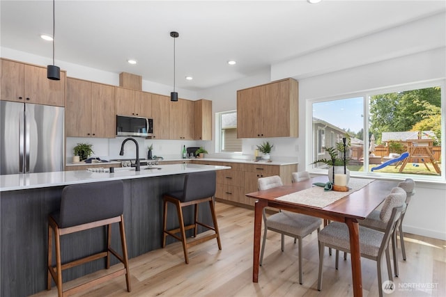 4710 Sagebrush Ln, Blaine, WA 98230 - kitchen featuring appliances with stainless steel finishes, light wood-style flooring, light countertops, a breakfast bar, and recessed lighting