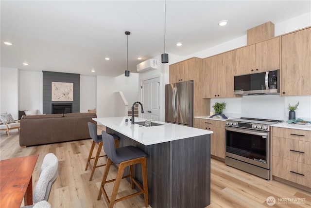 4710 Sagebrush Ln, Blaine, WA 98230 - kitchen with stainless steel appliances, modern cabinets, a breakfast bar, light wood-type flooring, and recessed lighting