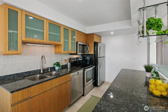 701 122nd Ave NE Unit 207, Bellevue, WA 98005 - kitchen featuring appliances with stainless steel finishes, decorative backsplash, light tile patterned floors, dark stone counters, and recessed lighting