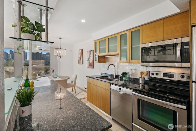 701 122nd Ave NE Unit 207, Bellevue, WA 98005 - kitchen featuring stainless steel appliances, tasteful backsplash, a chandelier, dark stone countertops, and glass insert cabinets