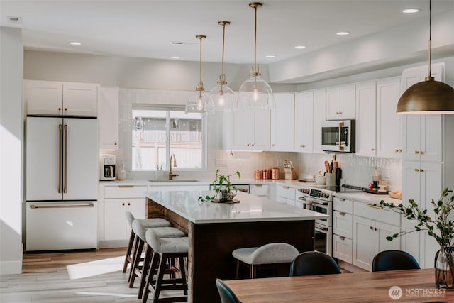 135 Main St E, Packwood, WA 98361 - kitchen featuring high end fridge, a breakfast bar, range with two ovens, light countertops, and backsplash